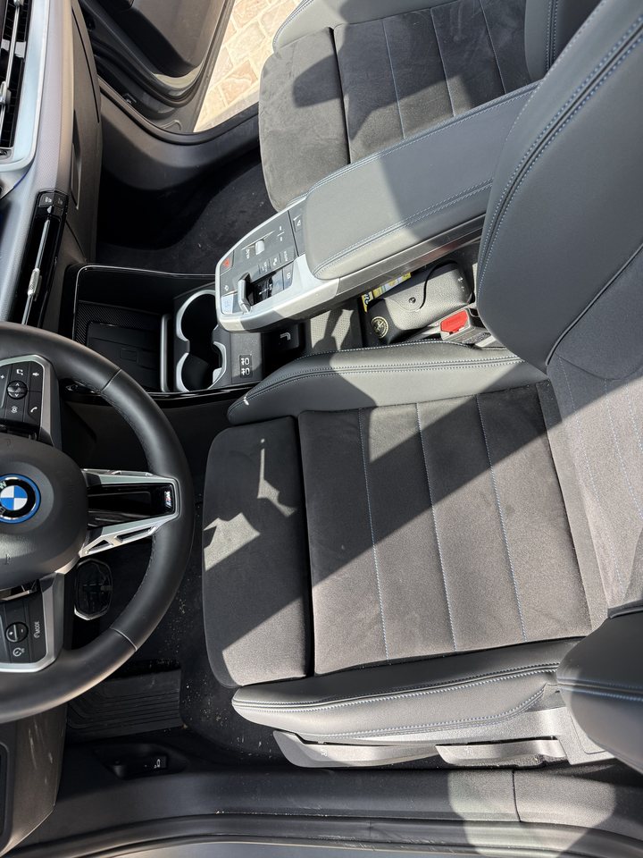 BMW avant nettoyage : miettes sur la moquette et dans la console