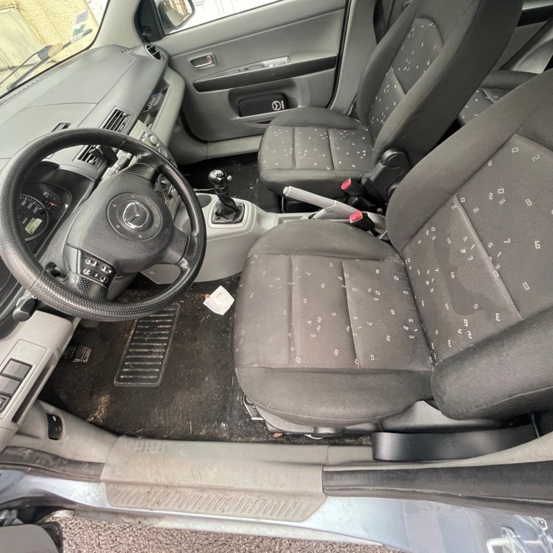 Mazda avant nettoyage : moquette pleine de terre et déchets